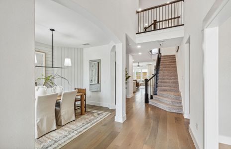 Welcoming entry into two-story ceilings and stairc