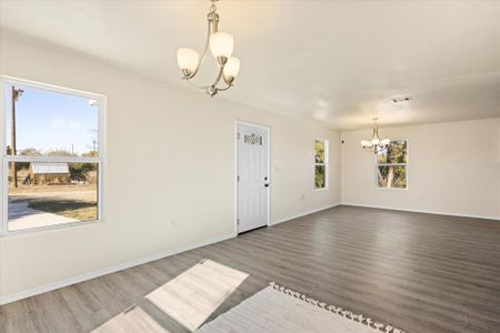 Unfurnished room featuring dark hardwood / wood-style floors and an inviting chandelier