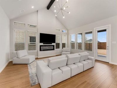 Living room impresses with a modern fireplace, soaring ceilings, and an accent beam