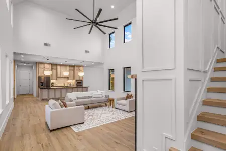 Living area with recessed lighting, visible vents, light wood finished floors, and stairs