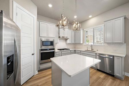 Outfitted with stainless steel appliances, including a gas range and double-door refrigerator, this kitchen combines style and efficiency.