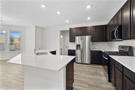 This kitchen will not disappoint! Your family and guests will enjoy many nights of fun, food and entertainment with ample counter space and kitchen island for setting up a wonderful array of provisions! This view of this gorgeous kitchen showcases SS appliances including refrigerator and microwave, silestone countertops, beautiful tile backsplash, gas range, high ceiling, recessed lighting and tile floors!