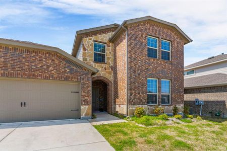 Traditional-style house featuring stone siding, brick siding, concrete driveway, and a garage Traditional-style house featuring stone siding, brick siding, concrete driveway, and a garage
