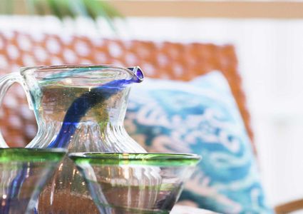 This home is decorated with blue throw pillows, mid-century modern sofa, and glass centerpiece.