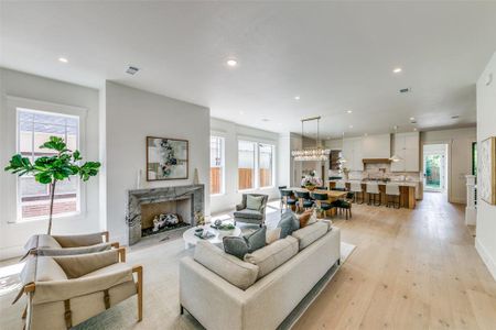 Living room featuring a fireplace, a healthy amount of sunlight, and light wood-type flooring