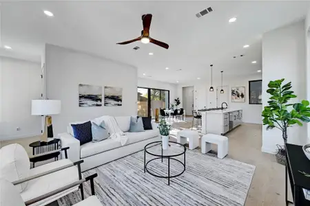 Living room with a ceiling fan, visible vents, baseboards, light wood-style flooring, and recessed lighting