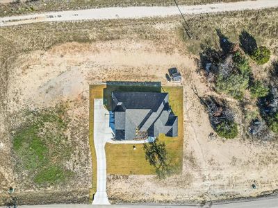 Aerial view of home. Lot includes partial trees to right and all of land on left - perfect space for a future shop!