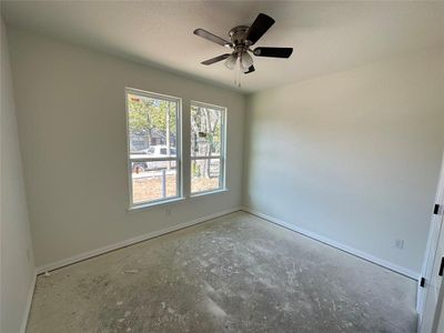 Empty room featuring ceiling fan and a textured ceiling