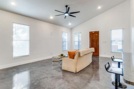 Living room with ceiling fan, concrete floors, and plenty of natural light