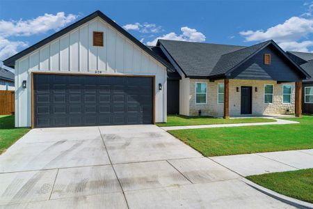 View of front of home featuring a garage and a front yard