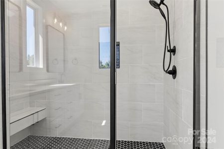 Large primary shower with tile and rain feature. Over head second shower outlet. Nice bench also