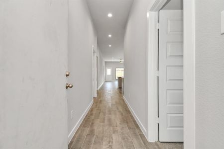 Greeted by a elegant glass front door (to be installed), the entrance beckons with high ceilings, adorned with elegant wood-look tile flooring and oversized baseboards. Sample photo of completed home with similar floor plan. Actual colors and selections may vary.