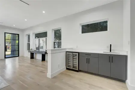 Wet Bar featuring gray cabinetry, beverage cooler, light hardwood / wood-style floors, and sink