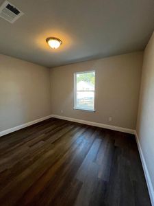 Spare room with dark wood-type flooring