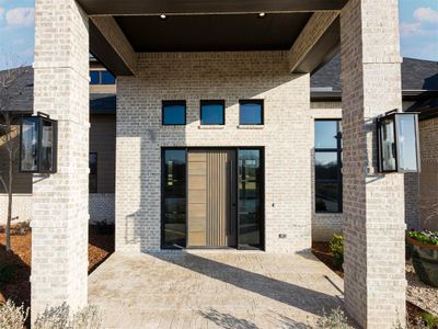 Beautiful covered exterior entry featuring wood door and decorative lighting.