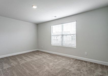 Secondary bedroom with carpet and a large window.