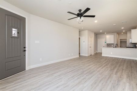 Unfurnished living room with light hardwood / wood-style floors and ceiling fan