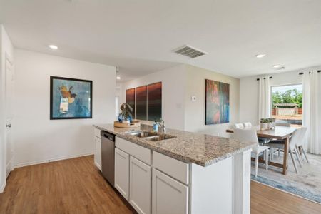 Kitchen featuring white cabinetry, sink, light wood-type flooring, and dishwasher