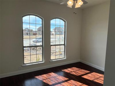 Empty room with ceiling fan and dark hardwood / wood-style floors