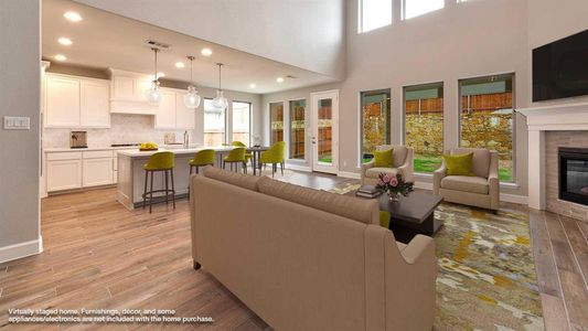 Living room featuring a tiled fireplace, a towering ceiling, and light hardwood / wood-style floors