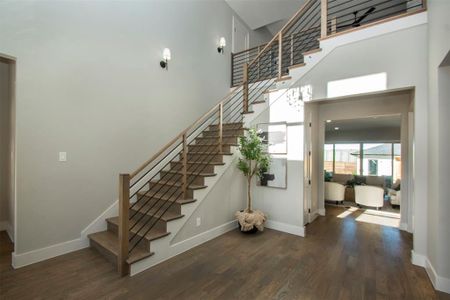 Stairs featuring hardwood / wood-style floors and a towering ceiling