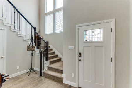 Foyer entrance with a towering ceiling and light hardwood / wood-style flooring