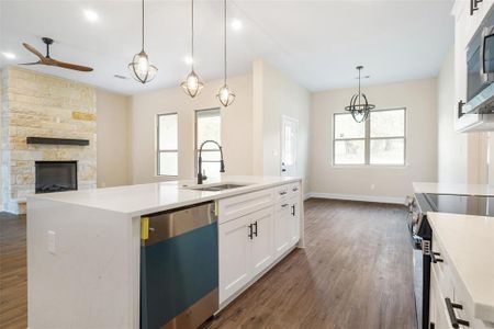 Kitchen featuring a center island with sink, dark hardwood / wood-style flooring, stainless steel appliances, and sink