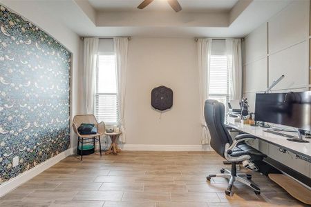 Office featuring ceiling fan and a tray ceiling