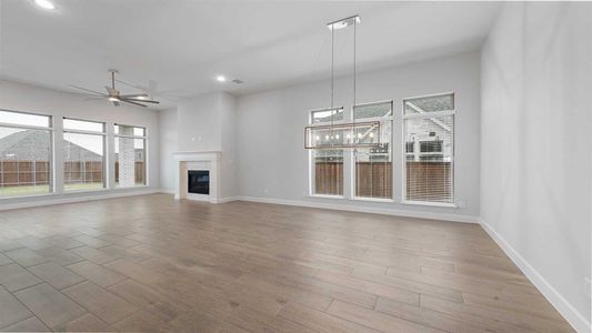 Unfurnished living room featuring ceiling fan and light hardwood / wood-style flooring