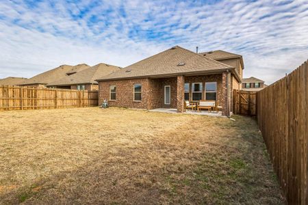 Back of house with a lawn and a patio