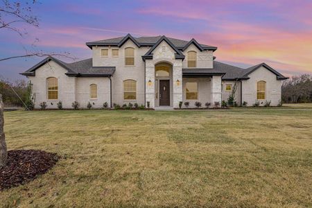 French country inspired facade with a lawn