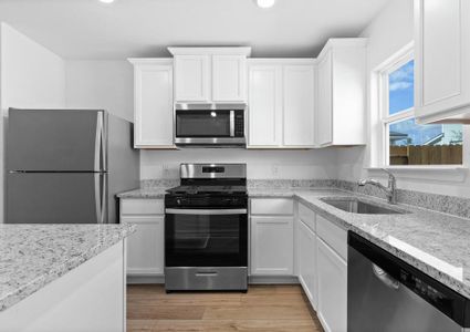 The kitchen comes filled with stainless steel appliances.