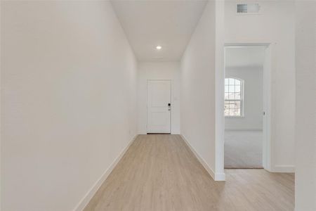 Corridor with light hardwood / wood-style flooring