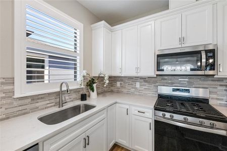 Plantation shutters and neutral quartz countertops and tile backsplash