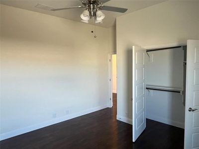 Unfurnished bedroom with a closet, ceiling fan, and dark hardwood / wood-style flooring