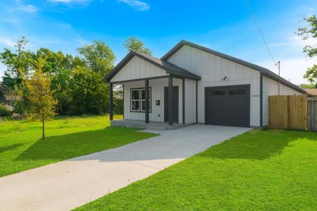 View of front facade featuring a front yard, a garage, and covered porch