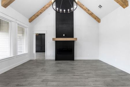 Unfurnished living room with beam ceiling, high vaulted ceiling, and dark hardwood / wood-style floors