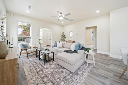 Living room with light hardwood / wood-style flooring and ceiling fan