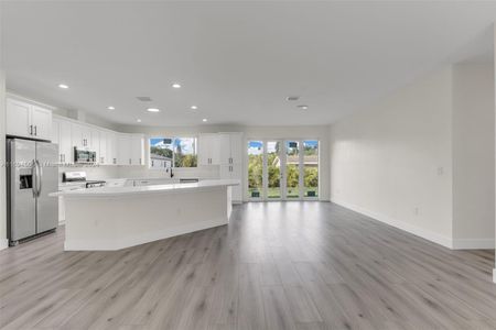 CUSTOM KITCHEN W/ CENTER ISLAND OVERLOOKING THE OPEN FLOOR PLAN LIVING ROOM.