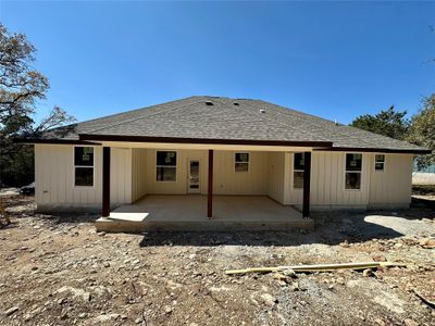 Back of property featuring a patio and roof with shingles