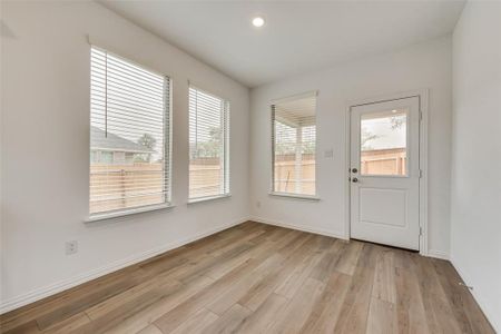 Doorway with plenty of natural light and light wood-type flooring