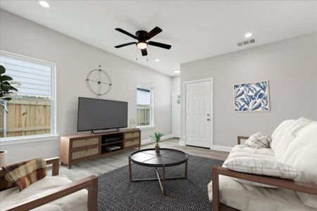 Living room with ceiling fan and hardwood / wood-style flooring