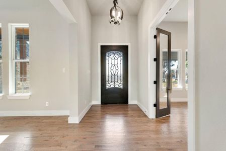 Foyer featuring light wood-type flooring and a chandelier