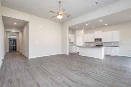 Unfurnished living room featuring light hardwood / wood-style flooring and ceiling fan