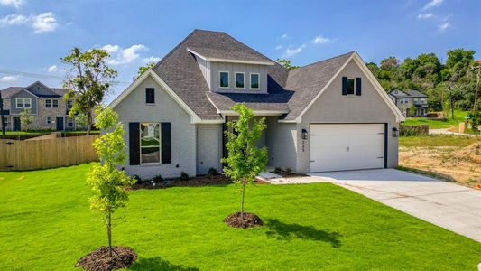 View of front of home with a garage and a front lawn