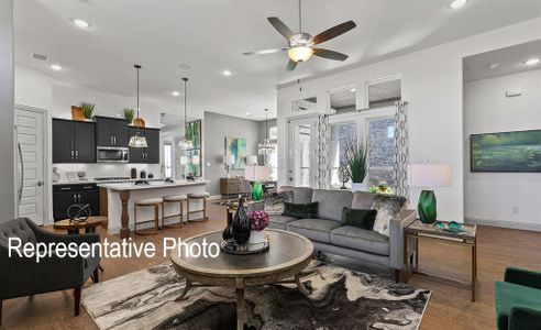 Living room featuring ceiling fan, a wealth of natural light, and dark hardwood / wood-style flooring