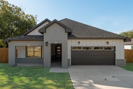 View of front of home featuring a front lawn and a garage