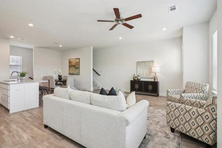 Living room with ceiling fan, sink, and light wood-type flooring