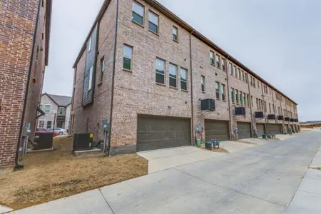 View of property with a garage and central AC