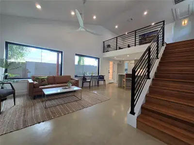 Huge open living room with lots of windows and an open loft looking out to the living space.